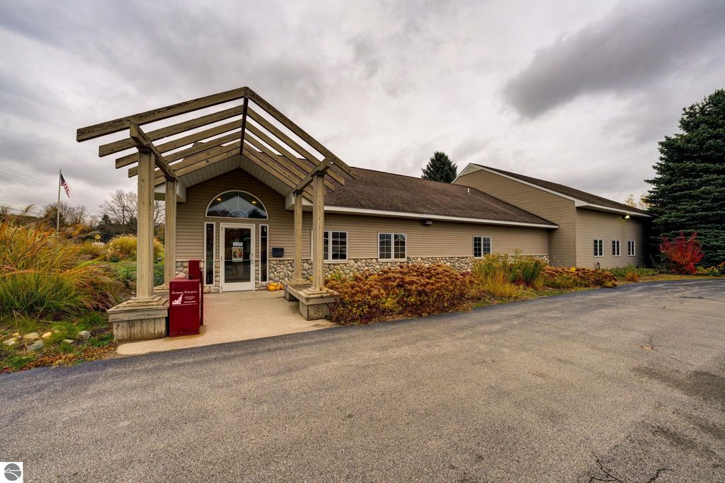 Commercial building exterior at 7200 E Duck Lake Road, Lake Leelanau, MI, featuring a welcoming entrance with a covered awning, landscaped surroundings, and visible signage for Leelanau Enterprise.