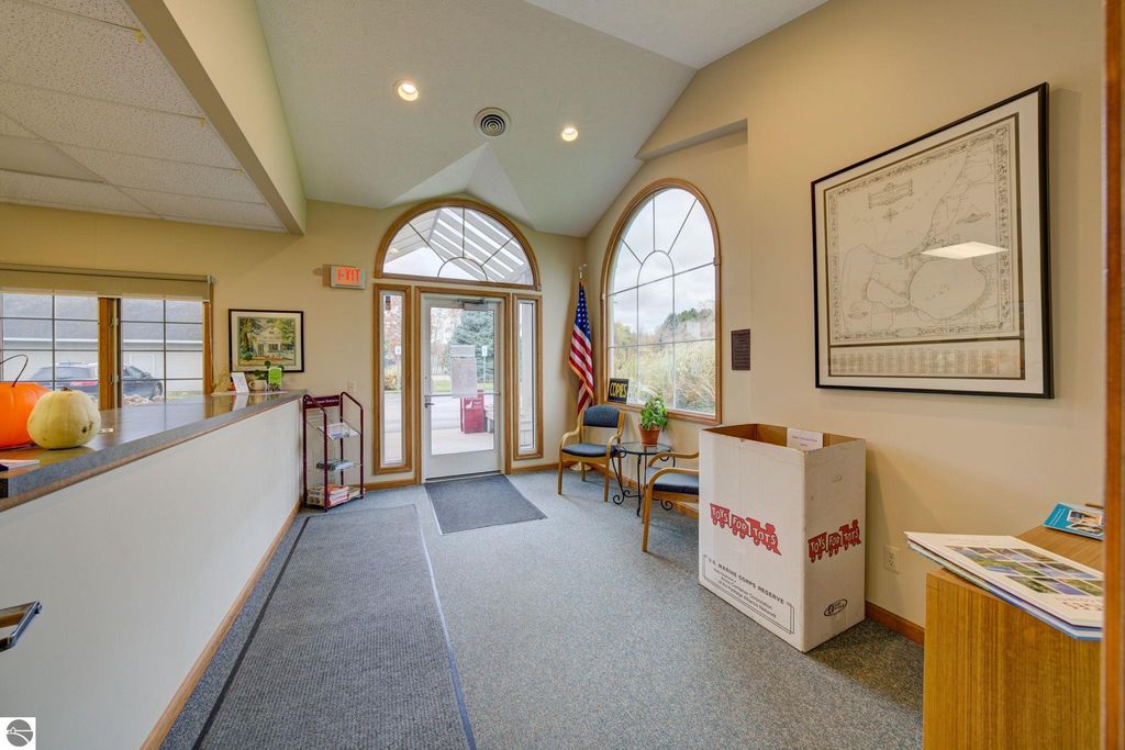 Interior reception area of commercial property featuring large windows, seating, and a donation box, highlighting the welcoming atmosphere for potential tenants and clients in Lake Leelanau.