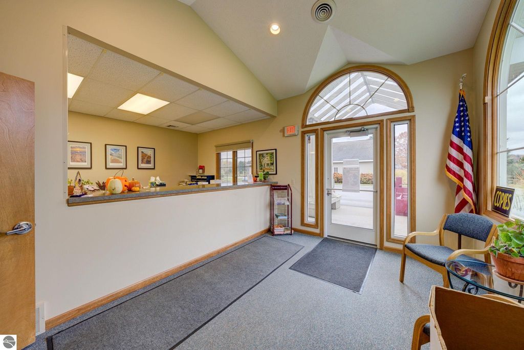 Reception area of a commercial property at 7200 E Duck Lake Road, featuring a front desk, seating, decorative pumpkins, and an American flag, highlighting the welcoming atmosphere for potential tenants and visitors.