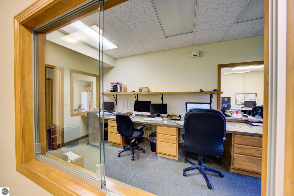 Office workspace with two desks, multiple computers, and storage, showcasing a professional environment for the leased commercial property at 7200 E Duck Lake Road, Lake Leelanau, MI.