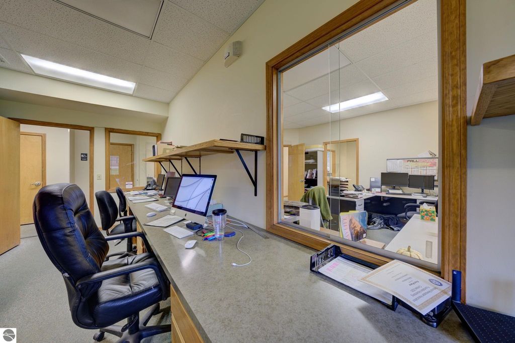 Office reception area with multiple desks, computers, and a view into a workspace, reflecting the commercial property at 7200 E Duck Lake Road, Lake Leelanau, MI.