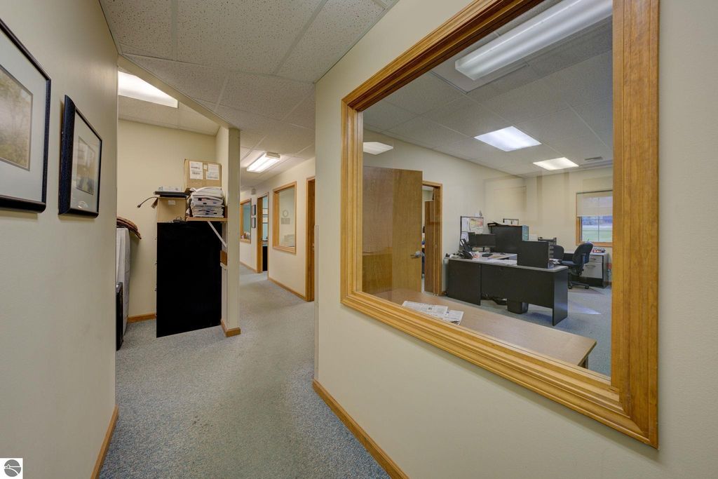 Office interior hallway view with multiple office doors, office furniture, and a reception area, highlighting the commercial space available at 7200 E Duck Lake Road, Lake Leelanau, MI.