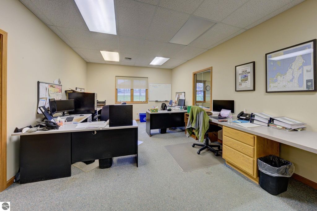 Office interior with multiple desks, computers, and office supplies, showcasing a workspace environment relevant to commercial real estate operations at 7200 E Duck Lake Road, Lake Leelanau, MI.