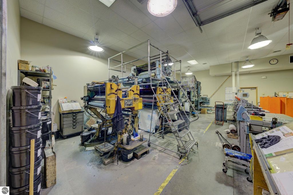 Printing machinery and workspace interior of commercial building in Lake Leelanau, showcasing production equipment and storage areas.