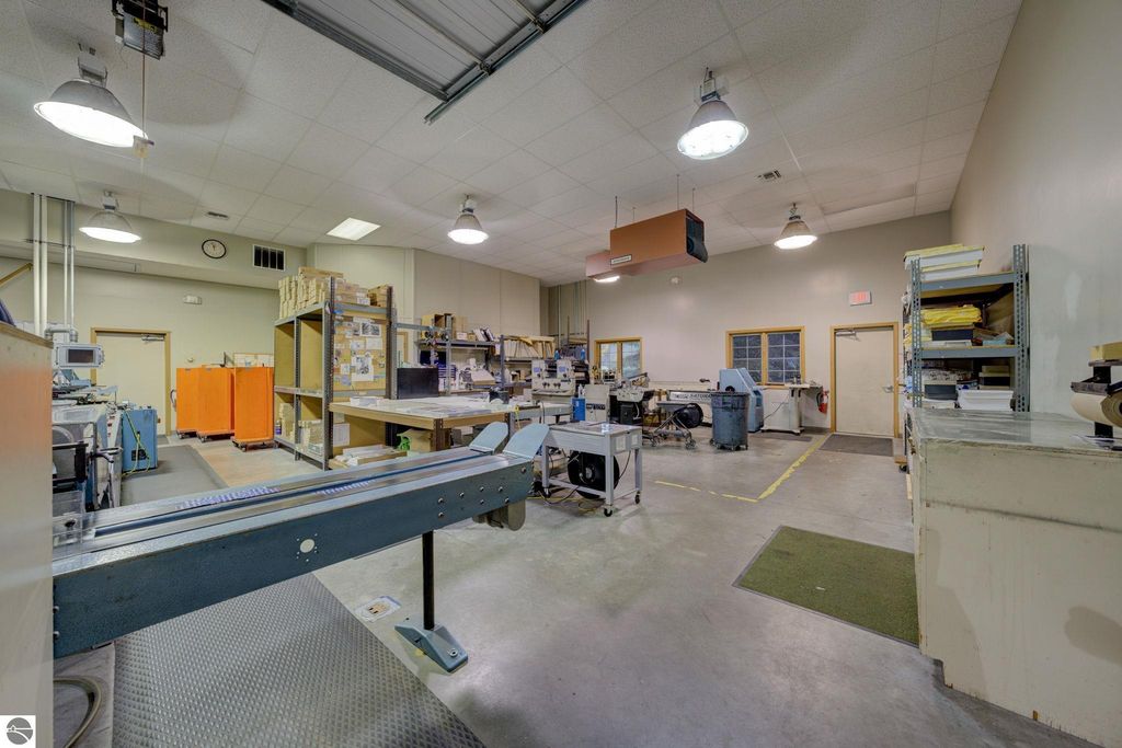 Commercial interior of a leased production space at 7200 E Duck Lake Road, featuring workstations, shelving, and manufacturing equipment, highlighting investment opportunity in Lake Leelanau.