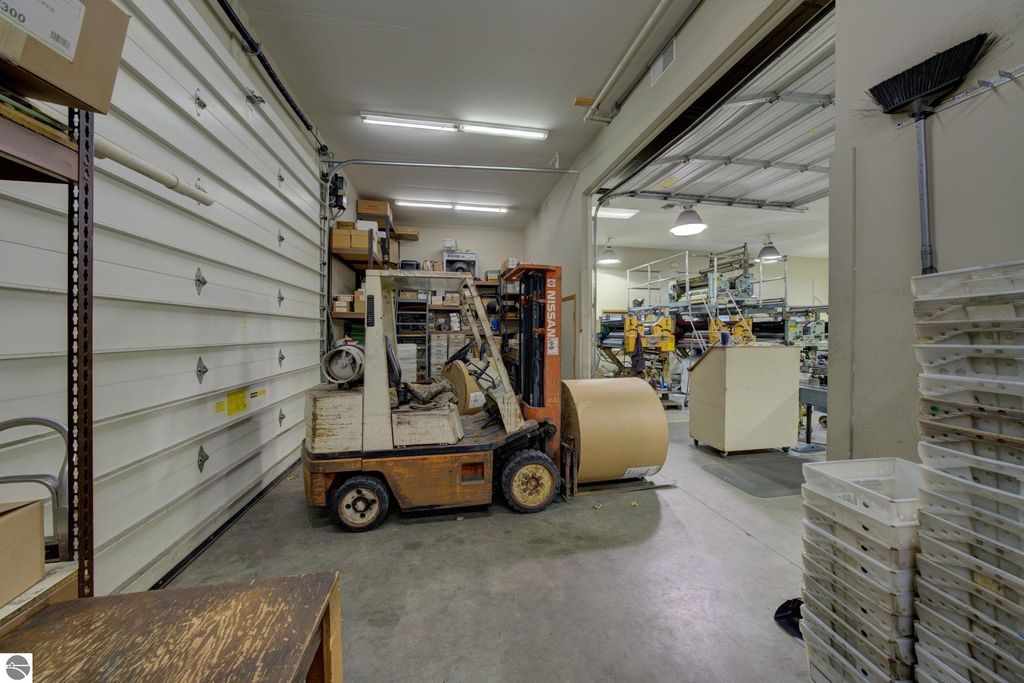 Forklift in a commercial storage space, showcasing organized boxes and production equipment, representing flexible potential for future build-out in Lake Leelanau, MI.