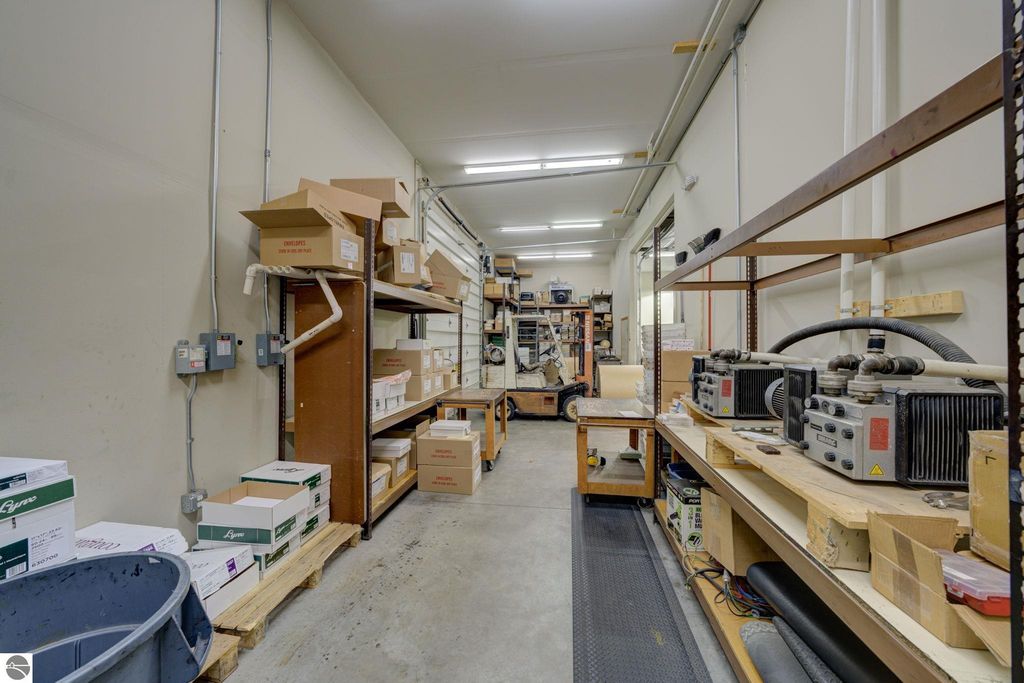 Commercial storage space with shelves, boxes, and equipment, highlighting flexible potential for future build-out in Lake Leelanau, MI property.