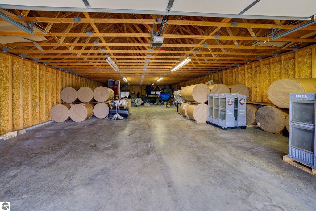 Interior view of a commercial storage building featuring stacked rolls of material, shelving units, and a concrete floor, highlighting flexible storage potential in Lake Leelanau, MI.