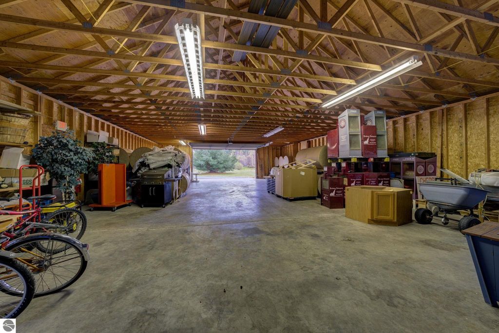 Interior view of a commercial storage building with various items including bicycles, furniture, and boxes, showcasing flexible potential for future build-out in Lake Leelanau, MI.