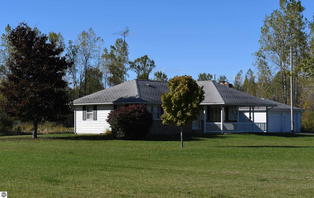 Ranch-style home at 2275 Noble Road, Tawas City, MI, surrounded by trees and open grassland, showcasing a peaceful outdoor lifestyle on 40 acres.