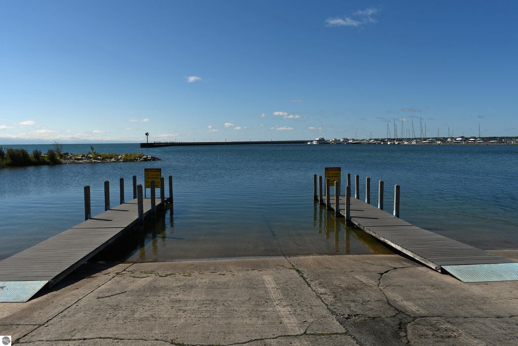 Dock leading to calm waters of Lake Huron, with a distant pier and boats, showcasing outdoor recreational opportunities near Tawas City.