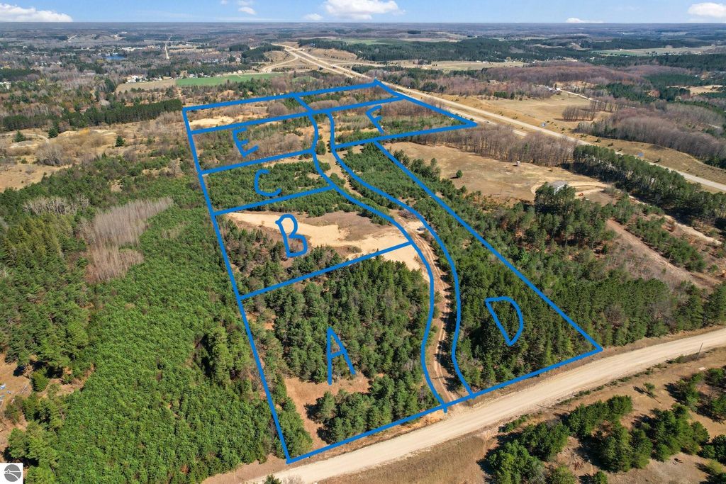 Aerial view of a 7.63-acre parcel of land in Manton, MI, with outlined sections labeled A, B, C, D, and E, showcasing wooded areas and a nearby road, ideal for outdoor retreats or home construction.
