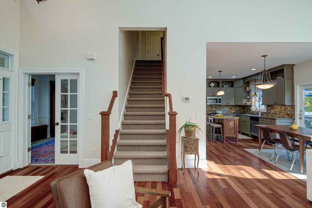 Interior view of a custom-designed home at 6436 Peregrin Court, featuring a staircase, hardwood floors, and an open kitchen layout, emphasizing modern comfort and elegant design.