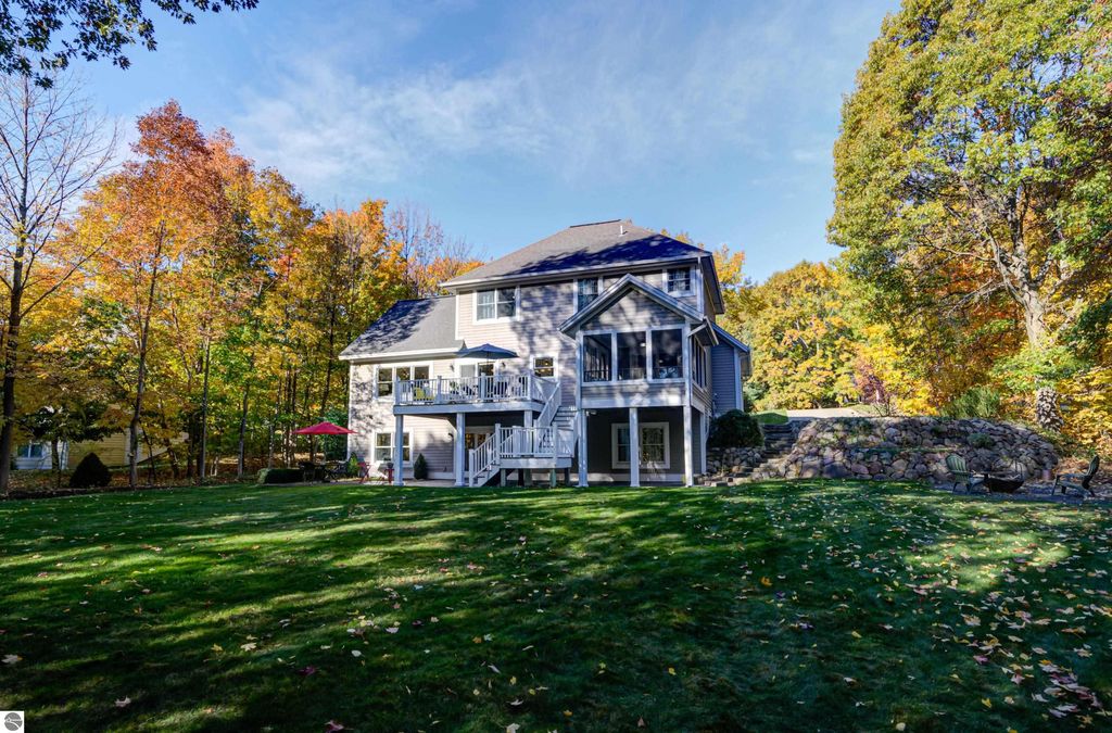 Custom-designed home at 6436 Peregrin Court, Traverse City, featuring a walkout lower level, spacious yard, and vibrant autumn foliage.