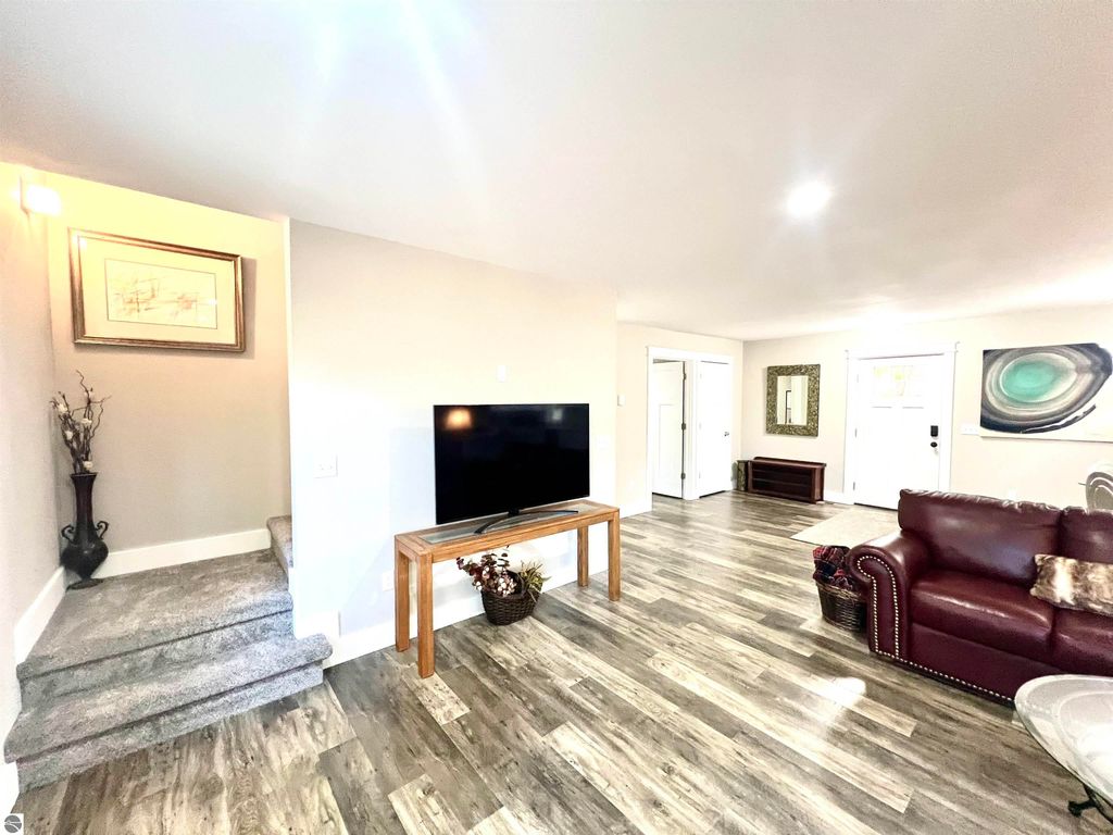 Spacious living room in a home at 2757 Fashion Avenue, featuring a television, hardwood flooring, a red leather sofa, and decorative elements, showcasing modern comfort and style.