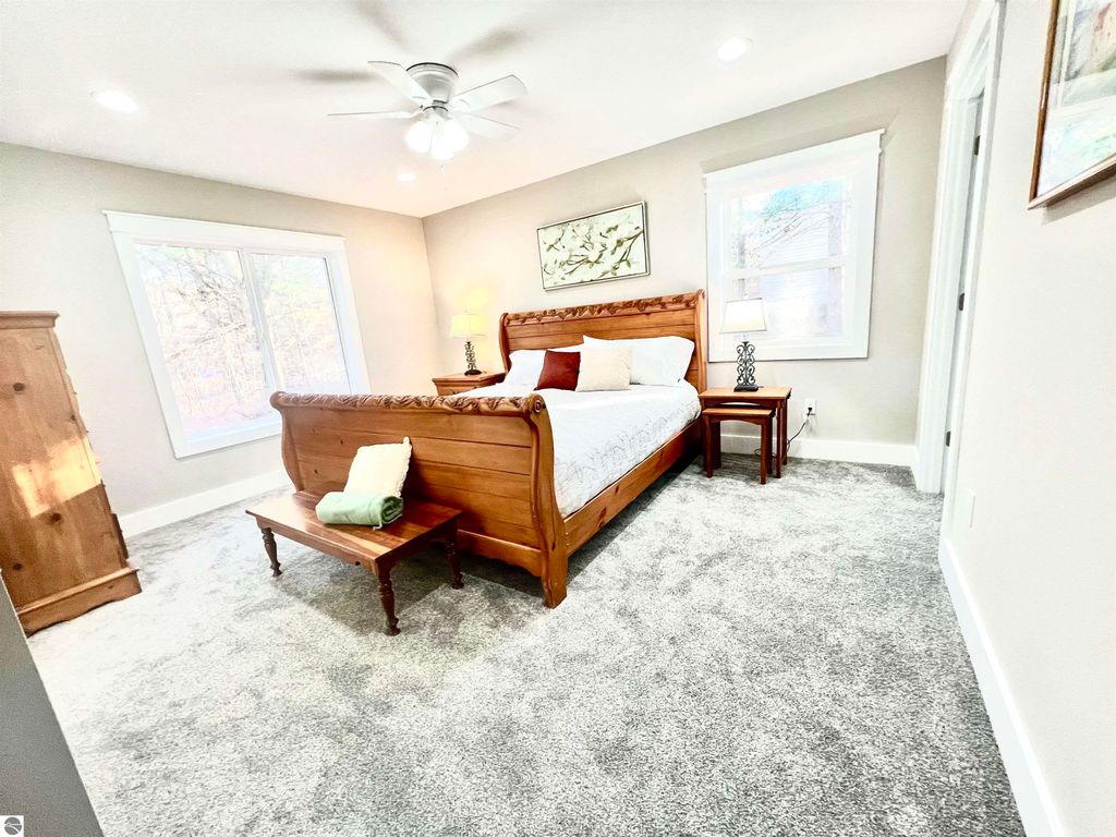 Spacious bedroom in a well-constructed home at 2757 Fashion Avenue, featuring a wooden sleigh bed, bedside table, and large windows, highlighting modern amenities and comfort.