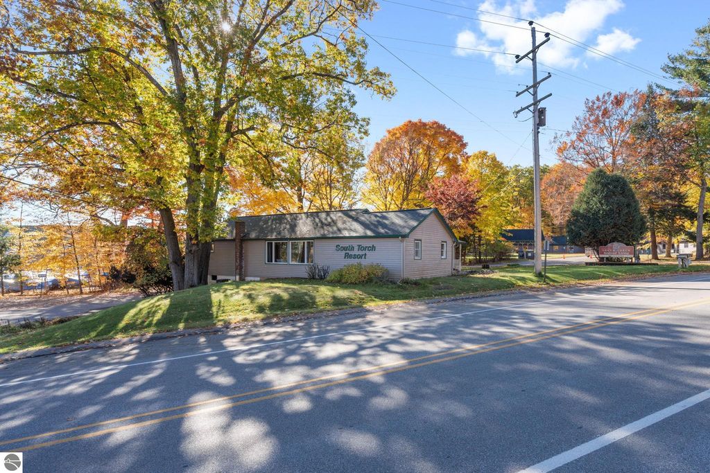 South Torch Resort building surrounded by autumn foliage, located near Torch Lake, Michigan, showcasing a welcoming exterior for a resort property ideal for investment and rental income.