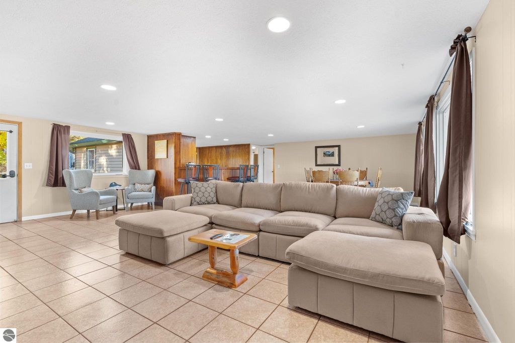 Spacious living area featuring a sectional sofa, dining space, and natural light, ideal for guests at the resort property near Torch Lake.