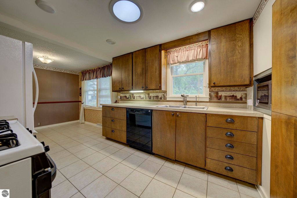 Galley kitchen in a well-maintained home at 624 Fenton Street, featuring wooden cabinets, tile flooring, and ample natural light from windows.