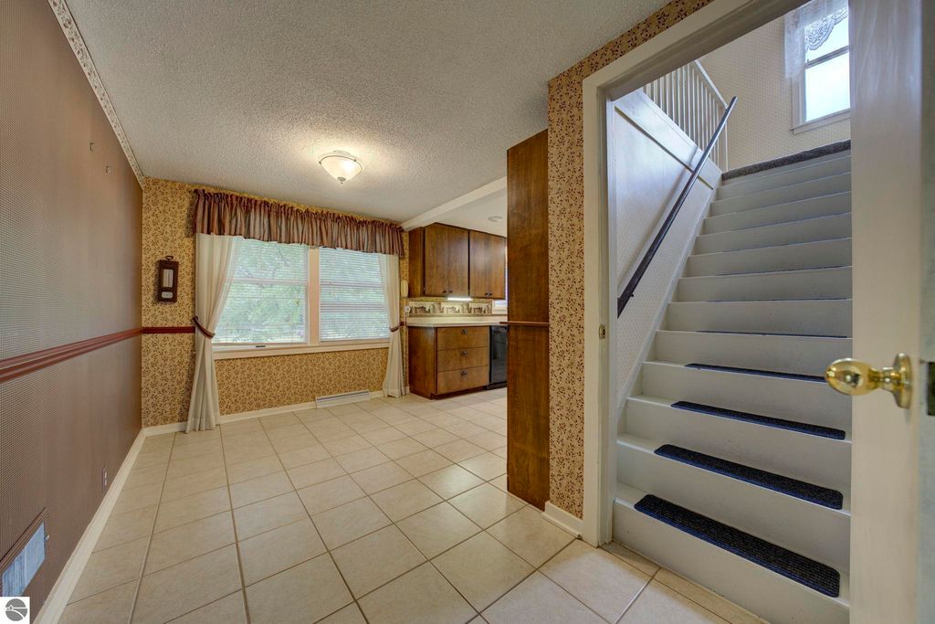 Interior view of a well-maintained home at 624 Fenton Street, featuring a tiled entryway, open concept living area leading to the kitchen, and a staircase to the upper level.