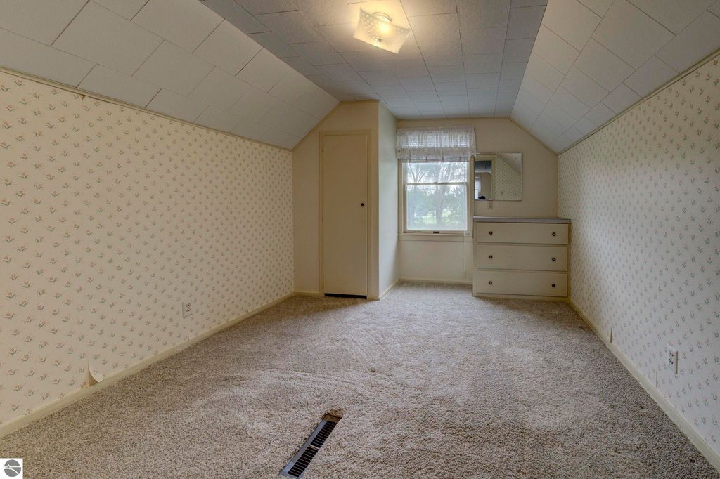 Bright and airy upstairs den area in a well-maintained home at 624 Fenton Street, featuring patterned wallpaper, a window with a view, and built-in dresser.