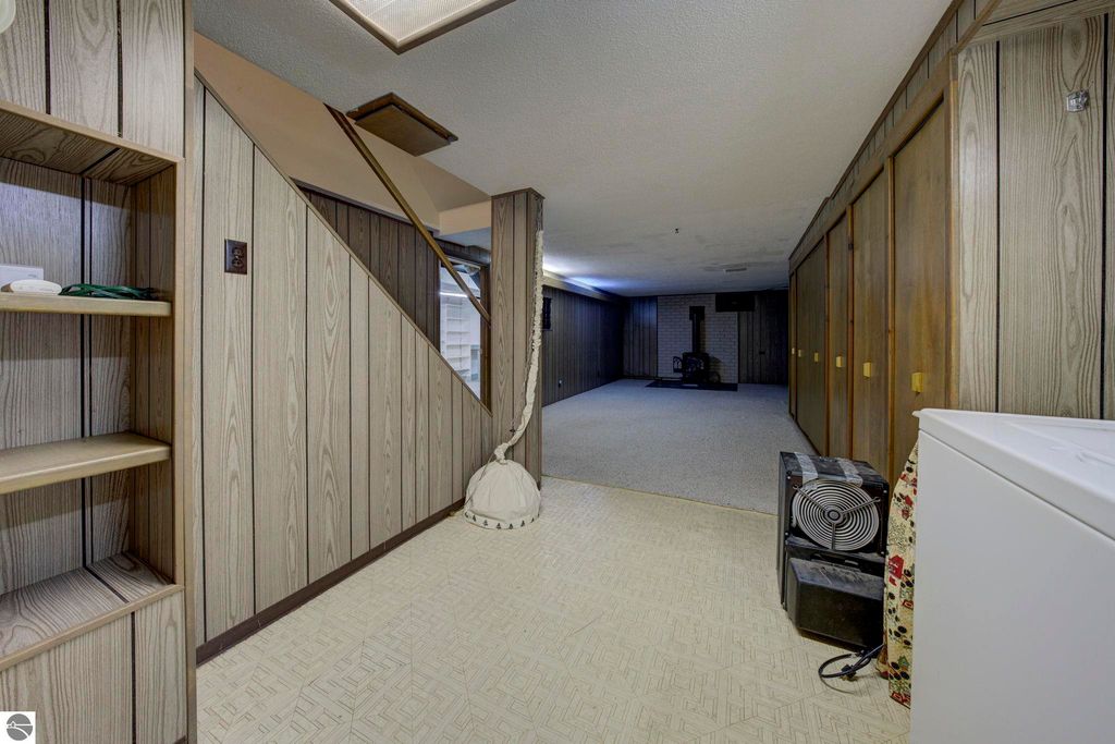 Basement rec-room in a well-maintained home at 624 Fenton Street, featuring wooden paneling, storage cabinets, and a visible brick fireplace, showcasing ample space for recreation and organization.