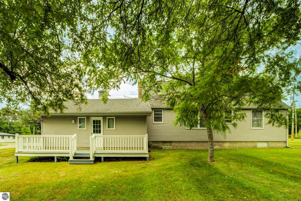 Well-maintained single-family home at 624 Fenton Street, Kingsley, MI, featuring a covered front porch, surrounded by greenery and a spacious yard.
