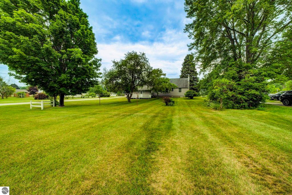 Well-maintained 1 1/2 story home on 0.44 acres with expansive lawn, surrounded by trees, located at 624 Fenton Street, Kingsley, MI.
