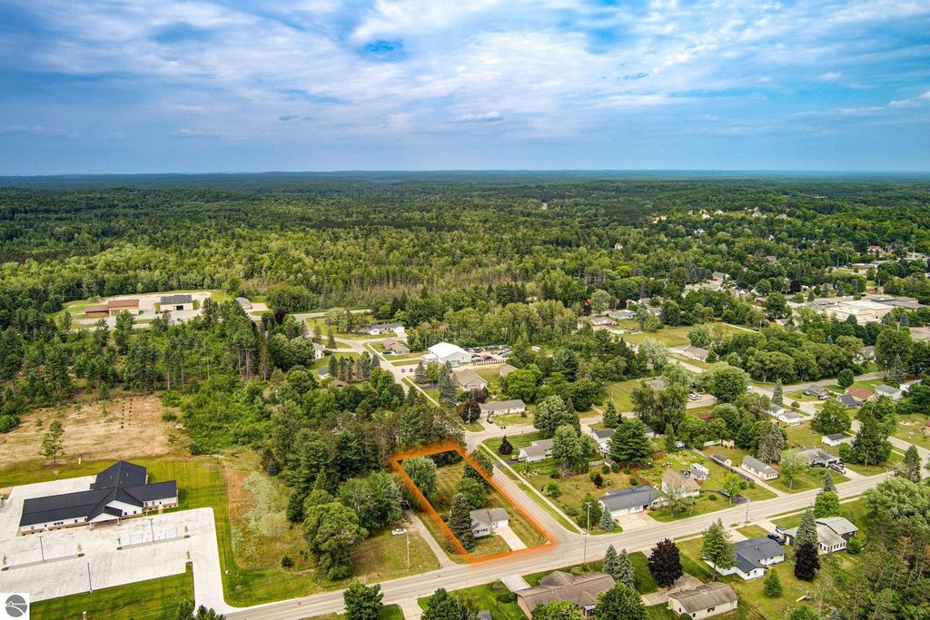 Aerial view of 624 Fenton Street, Kingsley, MI, showcasing the property's location on a double lot, surrounded by residential homes and greenery, highlighting nearby roads and open spaces.