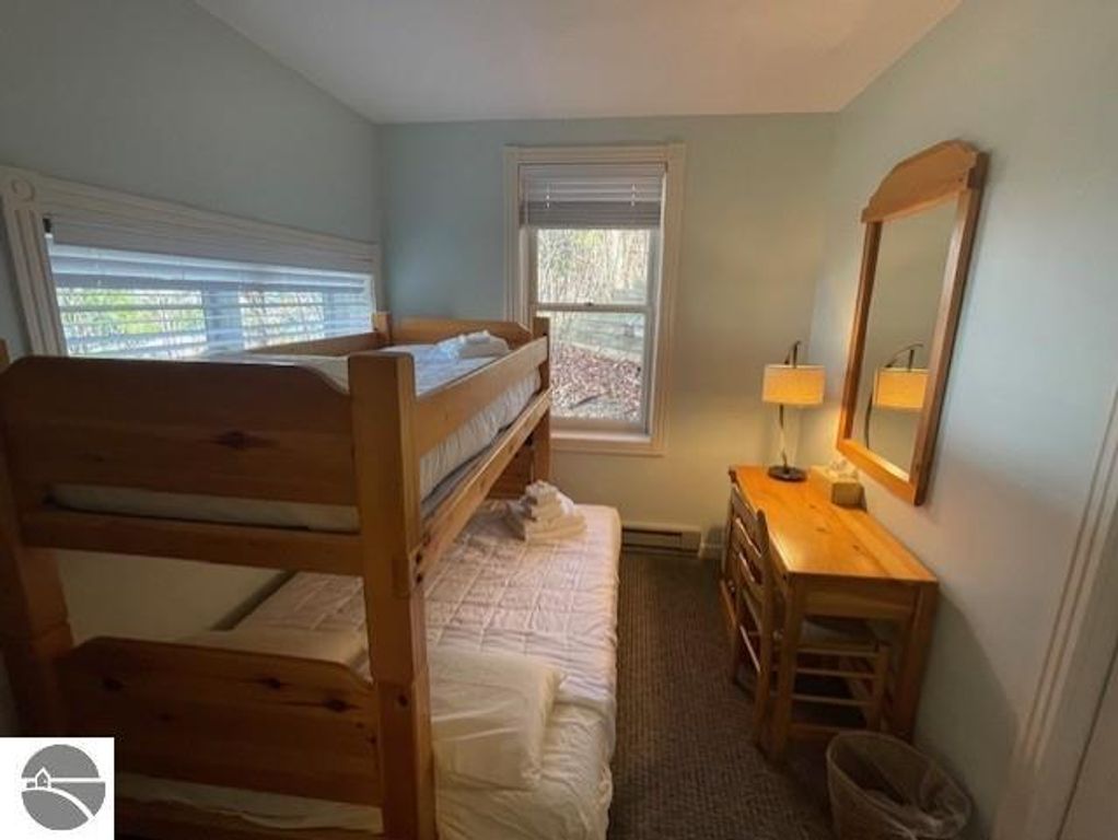 Bunk bed and wooden desk in a cozy bedroom with natural light, part of the 12C Pinnacle Place listing in Glen Arbor, MI.