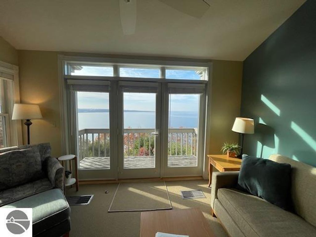 Cozy living area in Pinnacle Place 12C, featuring large windows with panoramic views of Lake Michigan, modern furnishings, and natural light.