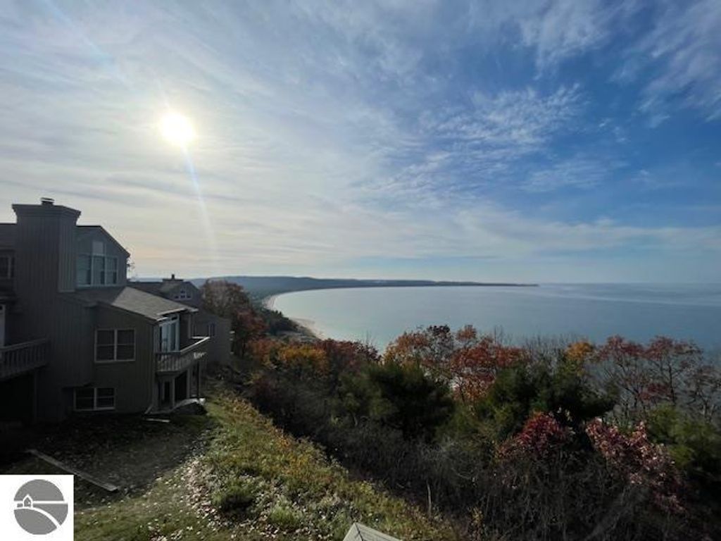 Panoramic view of Lake Michigan from Pinnacle Place, showcasing autumn foliage and coastal landscape with sunlight reflecting on the water.