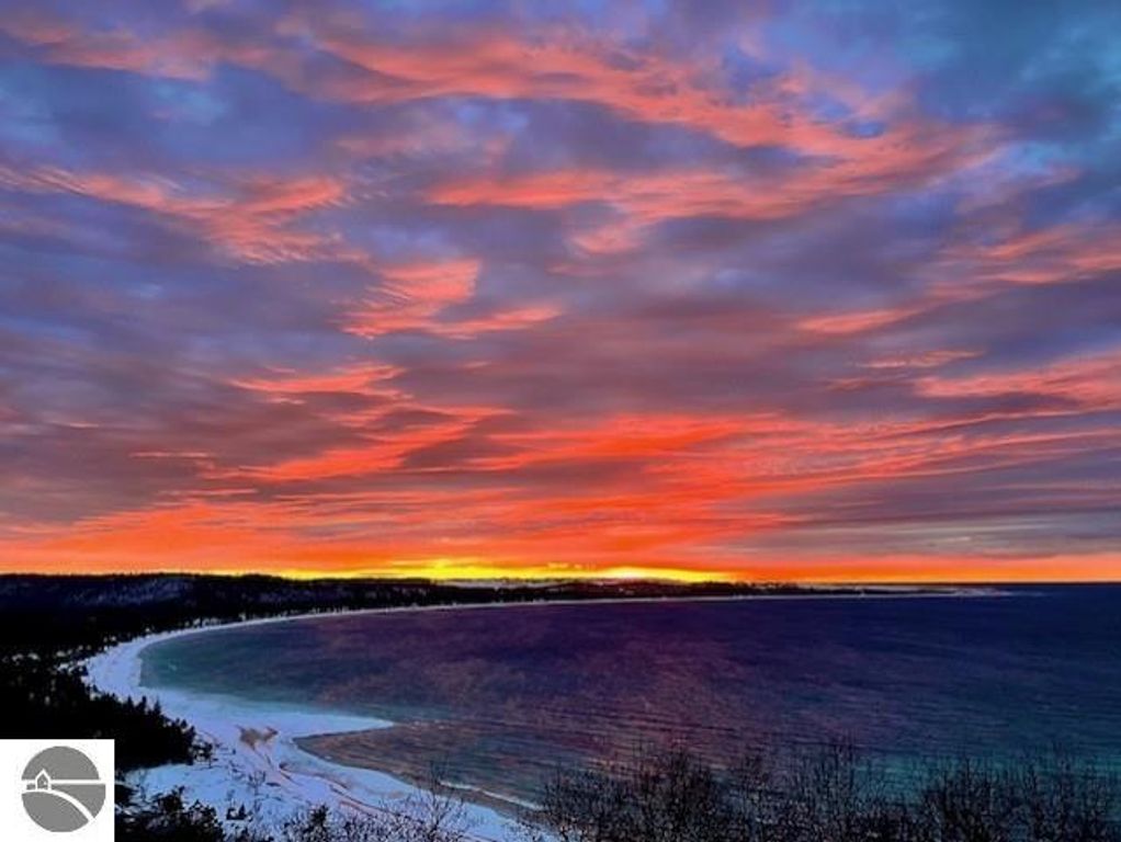 Panoramic sunset view over Lake Michigan, showcasing vibrant colors in the sky and tranquil waters, highlighting the scenic beauty of Glen Arbor, MI, near Pinnacle Place.