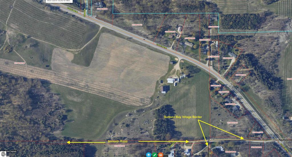 Aerial view of land parcel on E Duck Lake Road in Suttons Bay, MI, showcasing property boundaries, nearby roads, and surrounding farmland, highlighting development potential in Leelanau County.