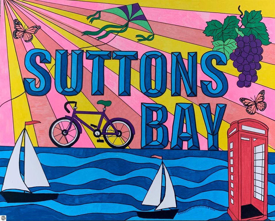 Colorful mural featuring "Suttons Bay" text, bicycle, sailboats, butterflies, grapes, and a phone booth against a vibrant background with rays, representing the scenic charm of Suttons Bay, MI.