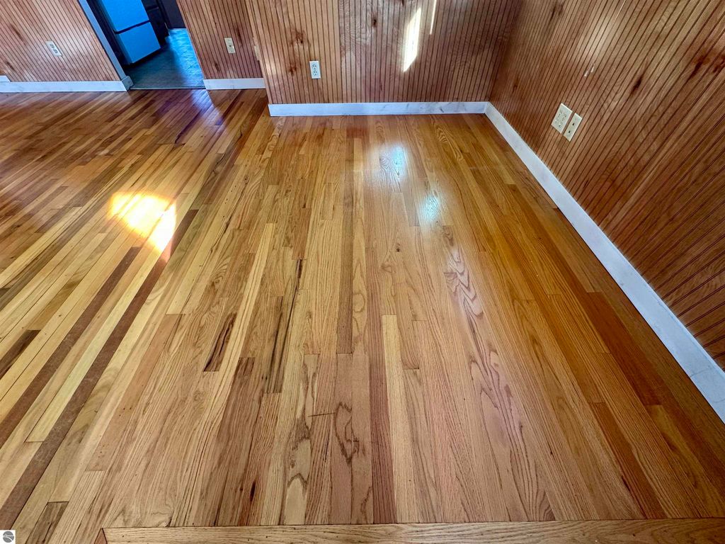 Hardwood floors in a bungalow at 224 W Fifteenth Street, Traverse City, showcasing fresh cleaning and natural light.