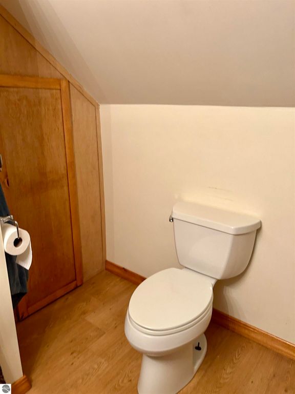 Bathroom with a white toilet and wooden cabinetry in a residential setting, showcasing the space's functionality and design.