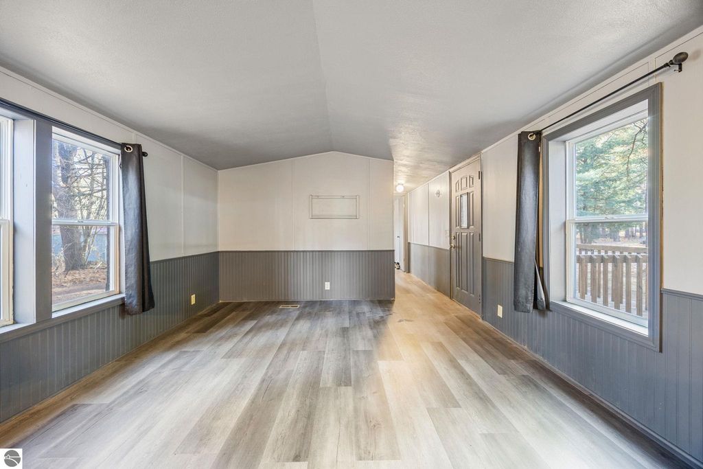 Spacious living area of a move-in ready home at 8401 Independence Avenue, featuring fresh paint, new flooring, and large windows providing natural light.