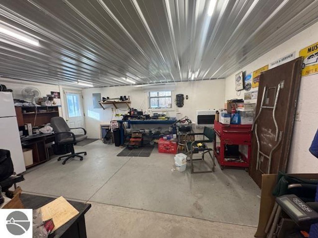 Interior of a spacious pole barn garage featuring a workbench, tools, and storage areas, highlighting a well-maintained space suitable for automotive work and hobbies.